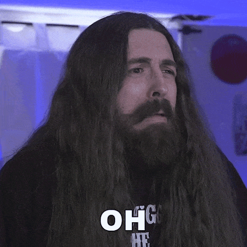 a man with long hair and a beard is wearing a black shirt that says god