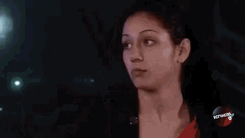 a close up of a woman 's face with a street light in the background at night .