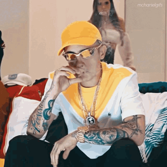 a man wearing a yellow hat and sunglasses smoking