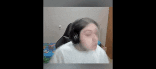a woman wearing headphones and a white shirt is sitting in a chair .