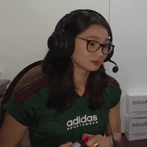a woman wearing a green adidas sportswear shirt