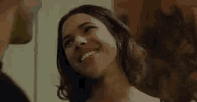 a man and a woman are looking into each other 's eyes and smiling .