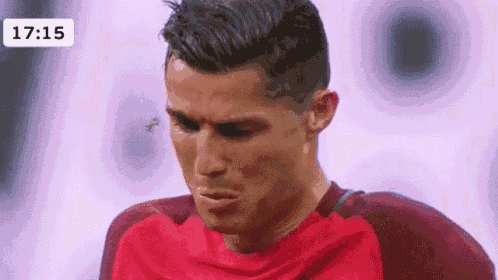 a close up of a soccer player 's face with a fly flying around his face .