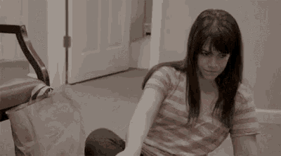 a woman is laying on the floor with her legs crossed and a bag on her lap .