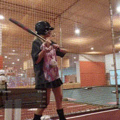 a person holding a baseball bat in front of a fence that says ' stadium '