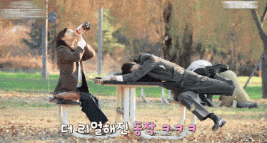 a man laying on a picnic table drinking from a bottle