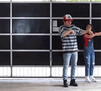 a man and a woman are dancing in front of a wall of shelves