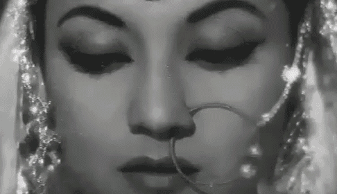 it is a black and white photo of a woman wearing a nose ring .
