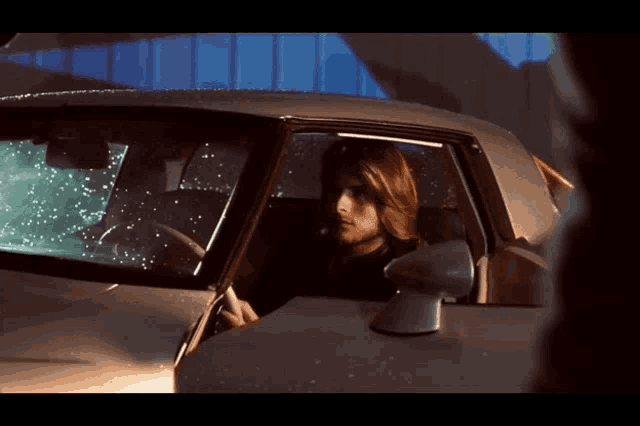 a man is sitting in a car with the door open