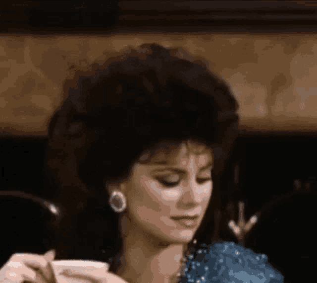 a woman with a big afro is drinking from a cup .