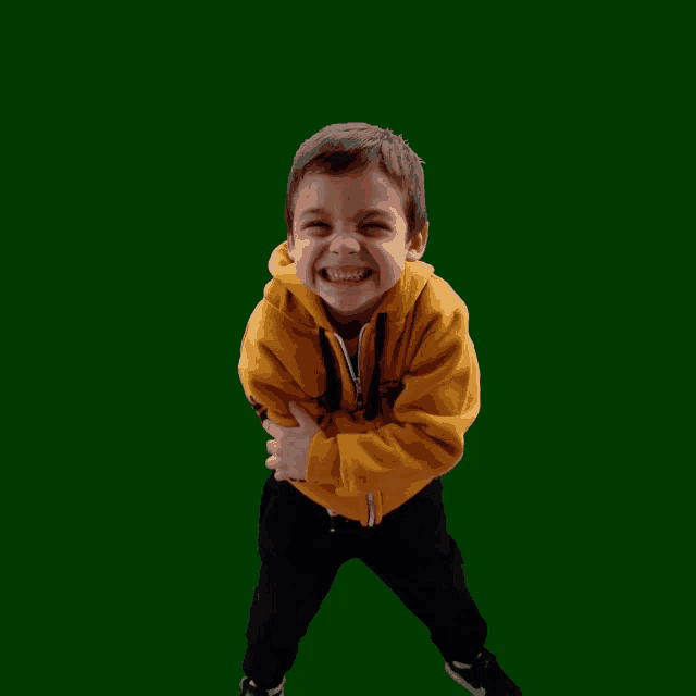 a young boy wearing a yellow sweatshirt with the word timberland on it laughs