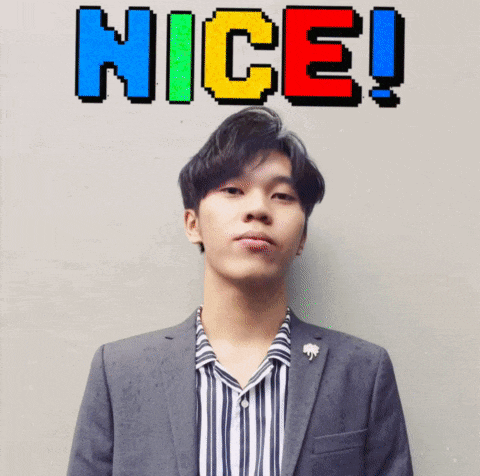 a man in a suit and striped shirt is standing in front of a wall with the word nice written on it