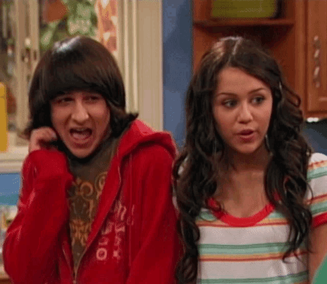 a boy wearing a red hoodie that says ' oi ' on it