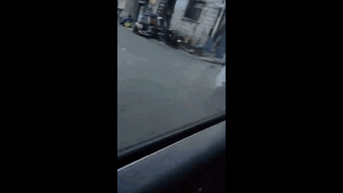 a person is sitting in the driver 's seat of a car and smoking a cigarette .