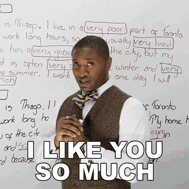 a man standing in front of a white board with the words " i like you so much " on it