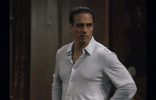 a man in a white shirt is standing with his hands on his hips