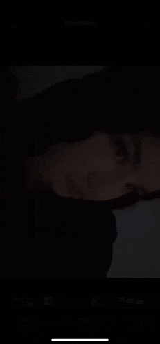a woman is taking a picture of herself in the dark .