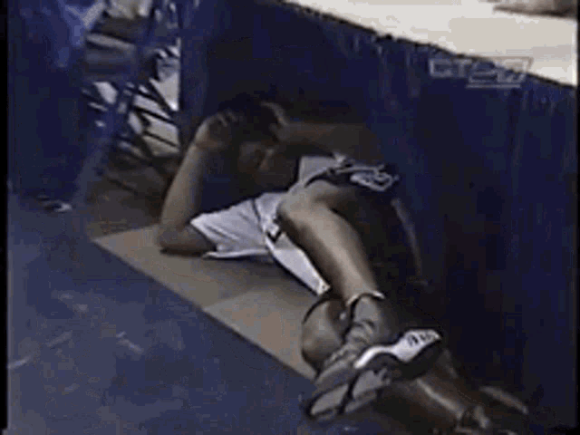 a man in a ucsd shirt is laying on the floor