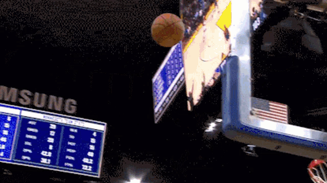 a basketball is flying through the air in front of a scoreboard that says samsung