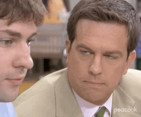 two men in suits and ties are looking at each other in a room .
