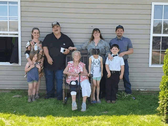 a family posing for a picture in front of their house
