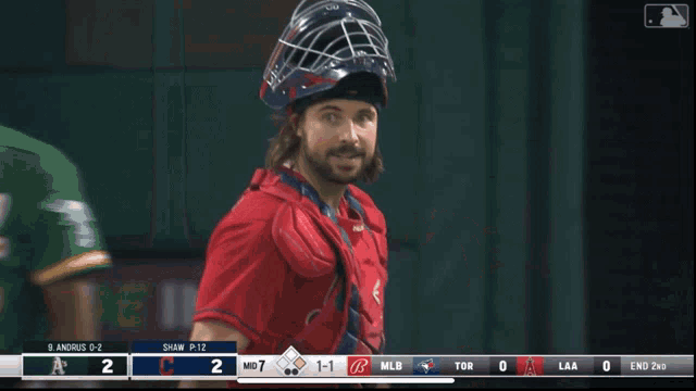 a baseball player wearing a helmet stands in front of a scoreboard that says mlb