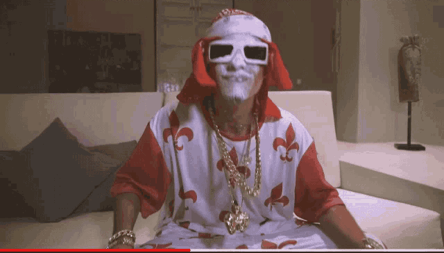 a man sitting on a couch wearing a mask and sunglasses