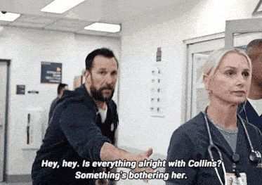 a man and a woman are talking in a hospital hallway and the man is saying " hey hey is everything alright with collins "