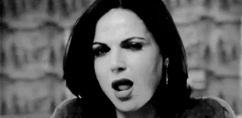a woman is making a funny face with her mouth open in a black and white photo .