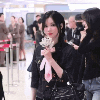 a woman is holding an ice cream cone in her hand while standing in an airport .