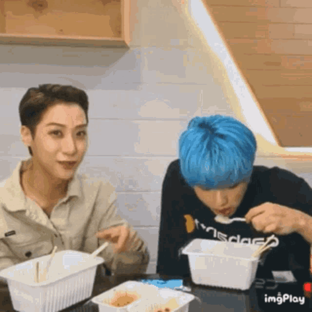 two people are sitting at a table eating food .