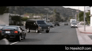 a black van is driving down a busy street
