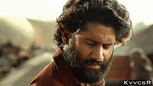 a close up of a man with a beard and the letters kvvcsr on the bottom