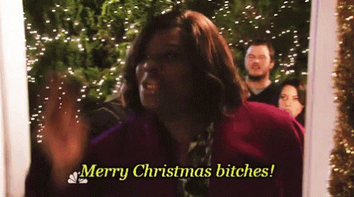 a man is standing in front of a christmas tree and says merry christmas bitches