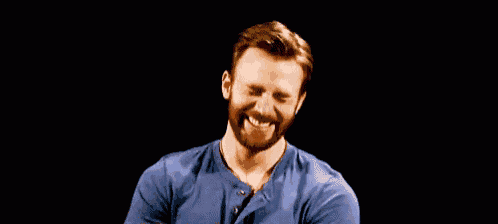 a man with a beard and a blue shirt is smiling .