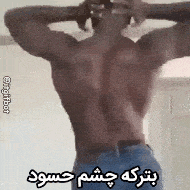 a man without a shirt is standing with his hands behind his head and a foreign language written below him