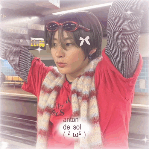 a person wearing sunglasses and a scarf has anton de sol written on the bottom