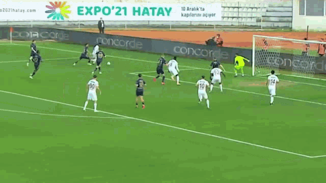 a group of soccer players on a field with a sign that says expo 21 hatay in the background