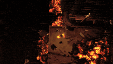 a person is standing in front of a large fire