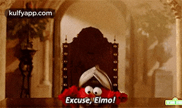 elmo from sesame street is sitting in a chair and saying excuse , elmo !