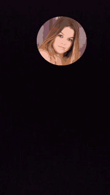 a woman 's face is visible through a hole in the wall
