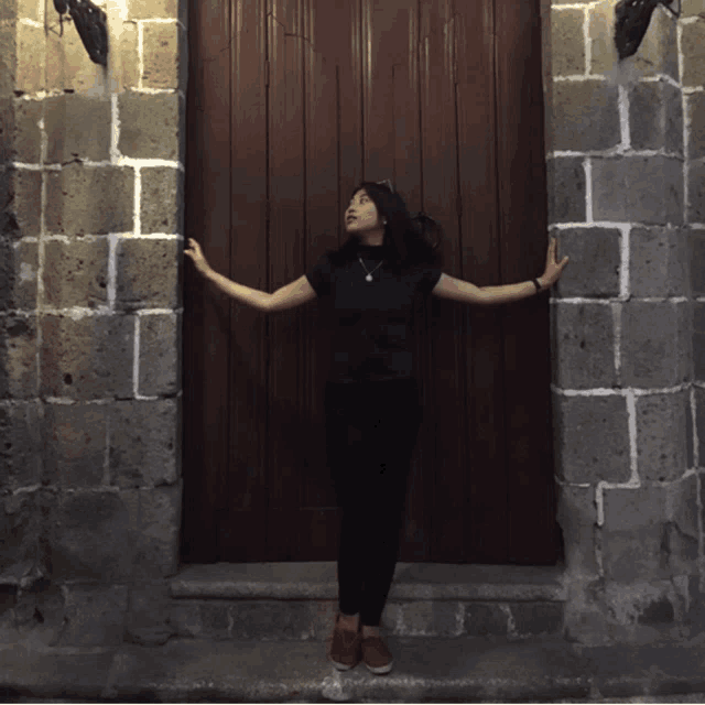 a woman standing in front of a wooden door