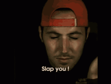 a man wearing a red hat is covering his mouth with his hand and says slap you