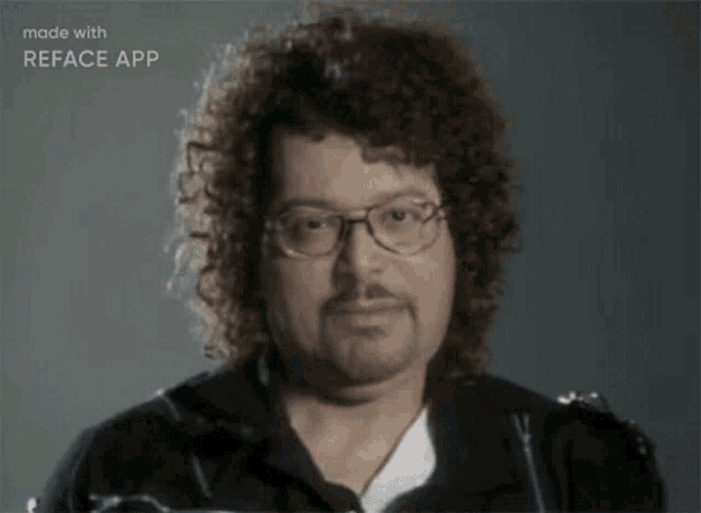 a man with curly hair wearing glasses and a beard is made with reface app