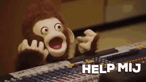 a stuffed monkey is sitting in front of a mixer with the words help mij written on it .