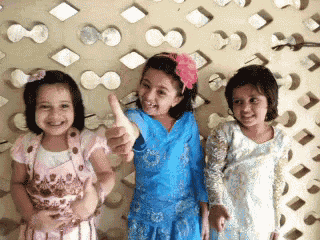 three little girls are giving a thumbs up sign