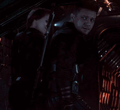 a man and a woman are standing next to each other and the woman is wearing a watch that says ' avengers '