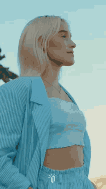 a woman wearing a blue striped jacket and crop top