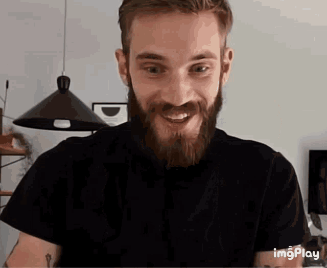 a man with a beard wearing a black t-shirt with imgplay written on the bottom