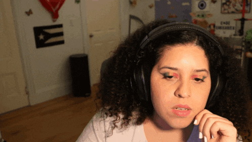 a woman wearing headphones in front of a wall with a cuban flag on it
